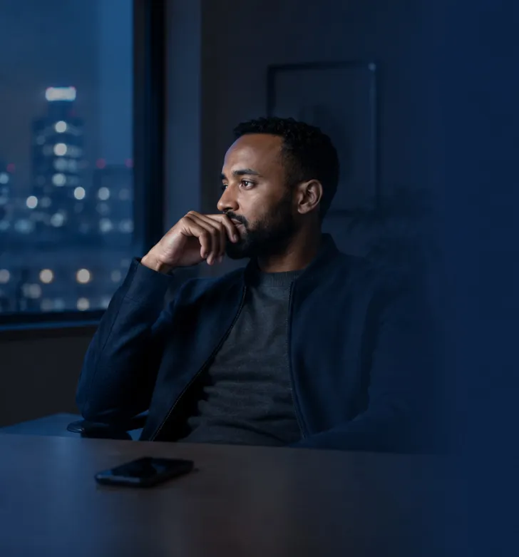 Leader sitting at desk at night reflecting on leadership challenges